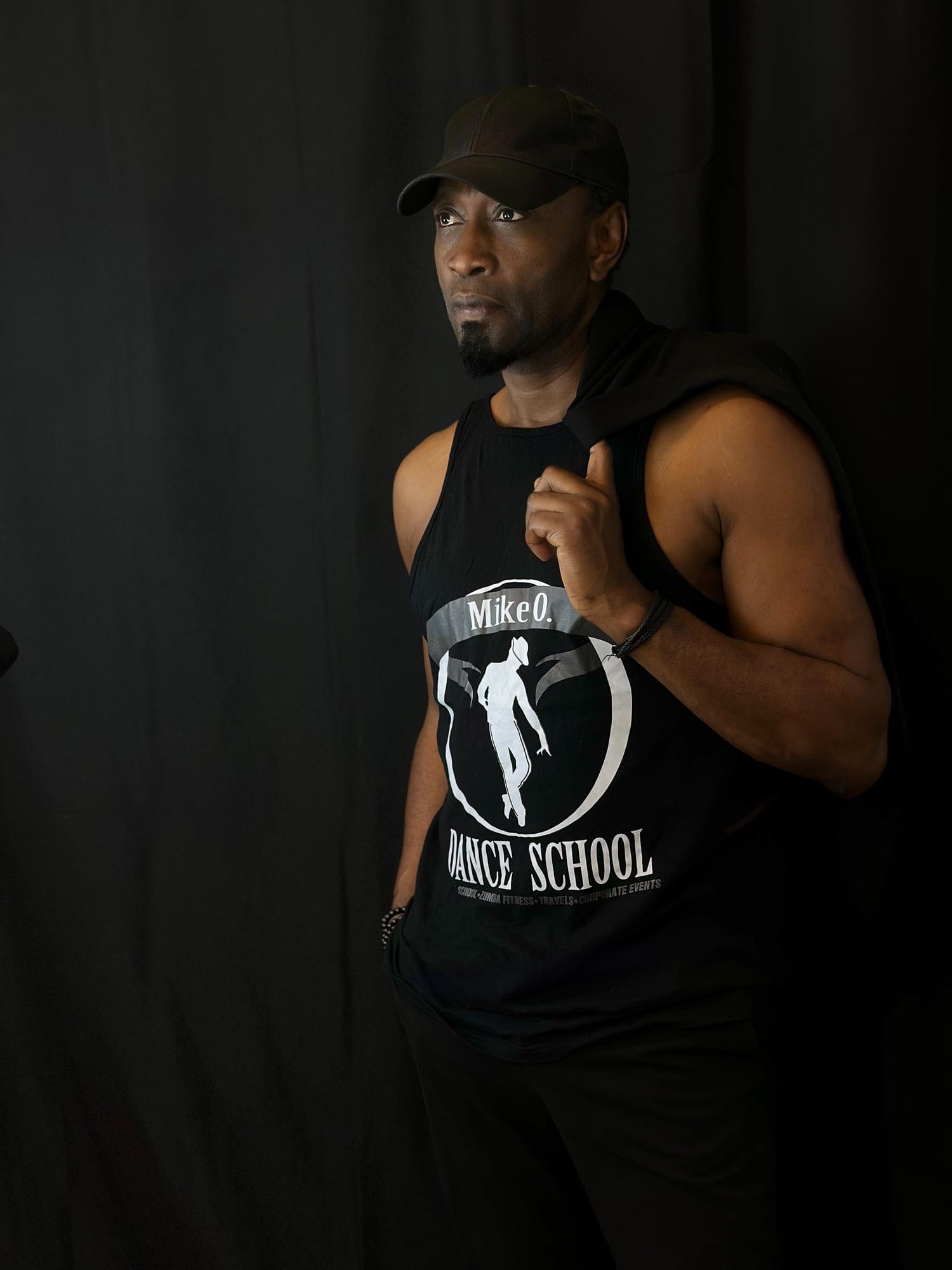 Mike O., fondateur d'O'Dance School, devant un rideau noir