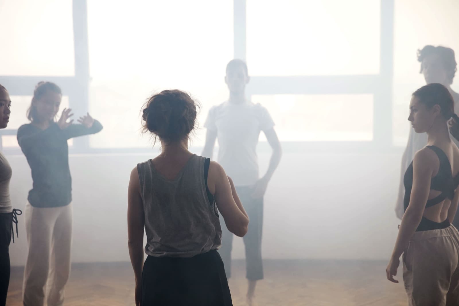 Des danseurs en plein travail dans un studio baigné de lumière