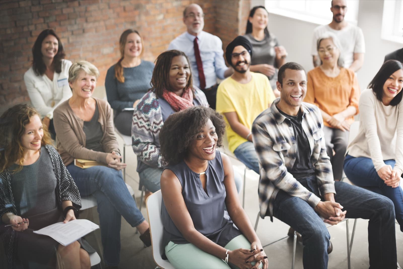 Un public varié et souriant lors d'une présentation de la formation DCM