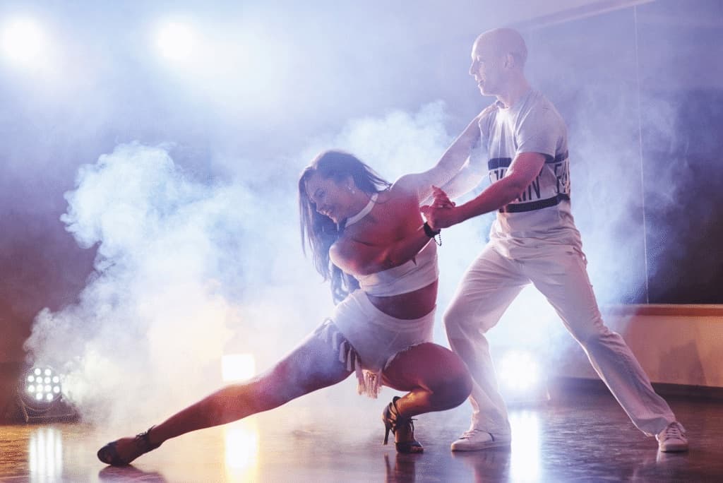Un couple de danseurs O'Dance en représentation, sous les lumières de scène