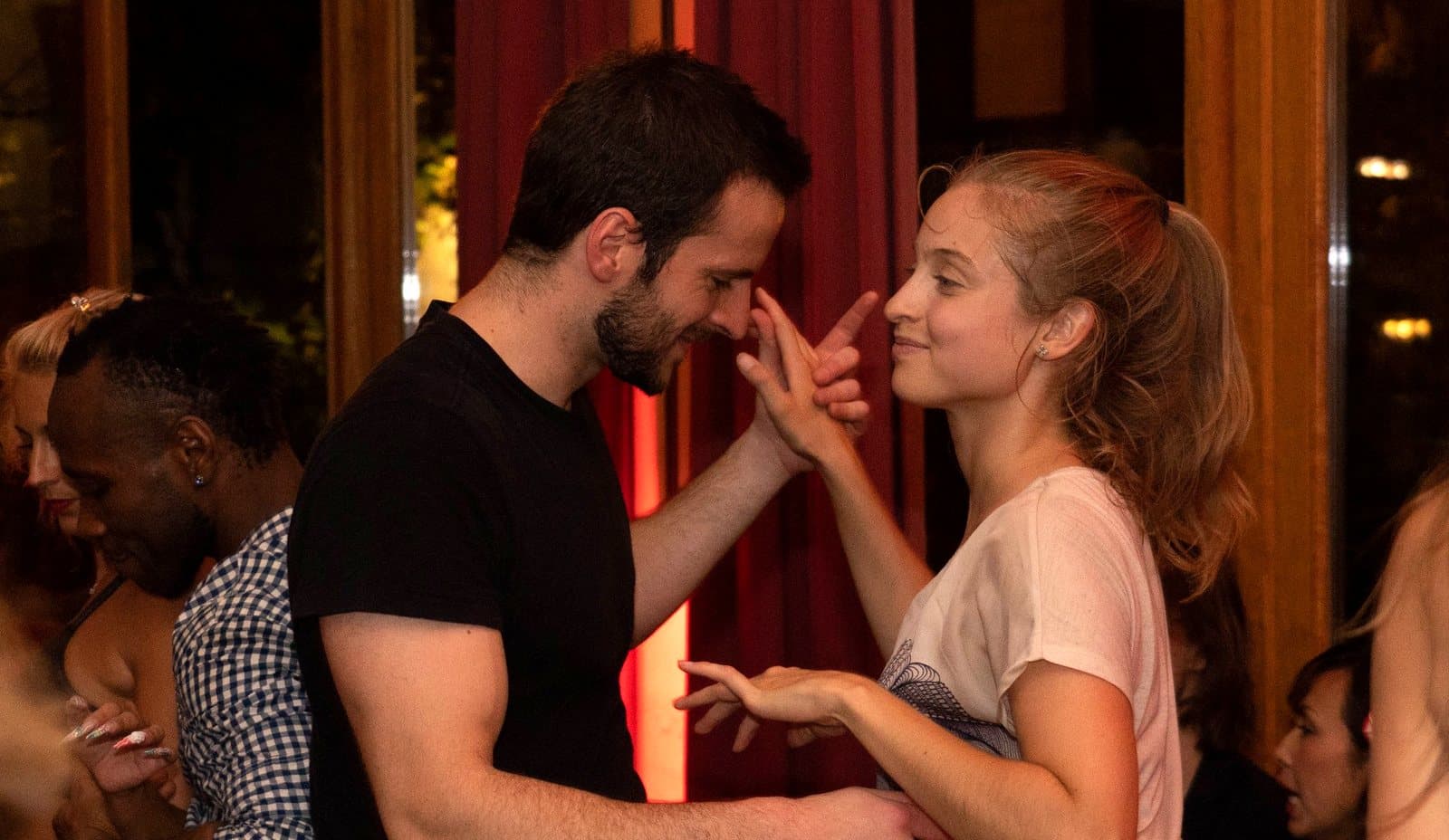 Un jeune couple souriant danse la salsa pendant un cours O'Dance à Bruxelles.