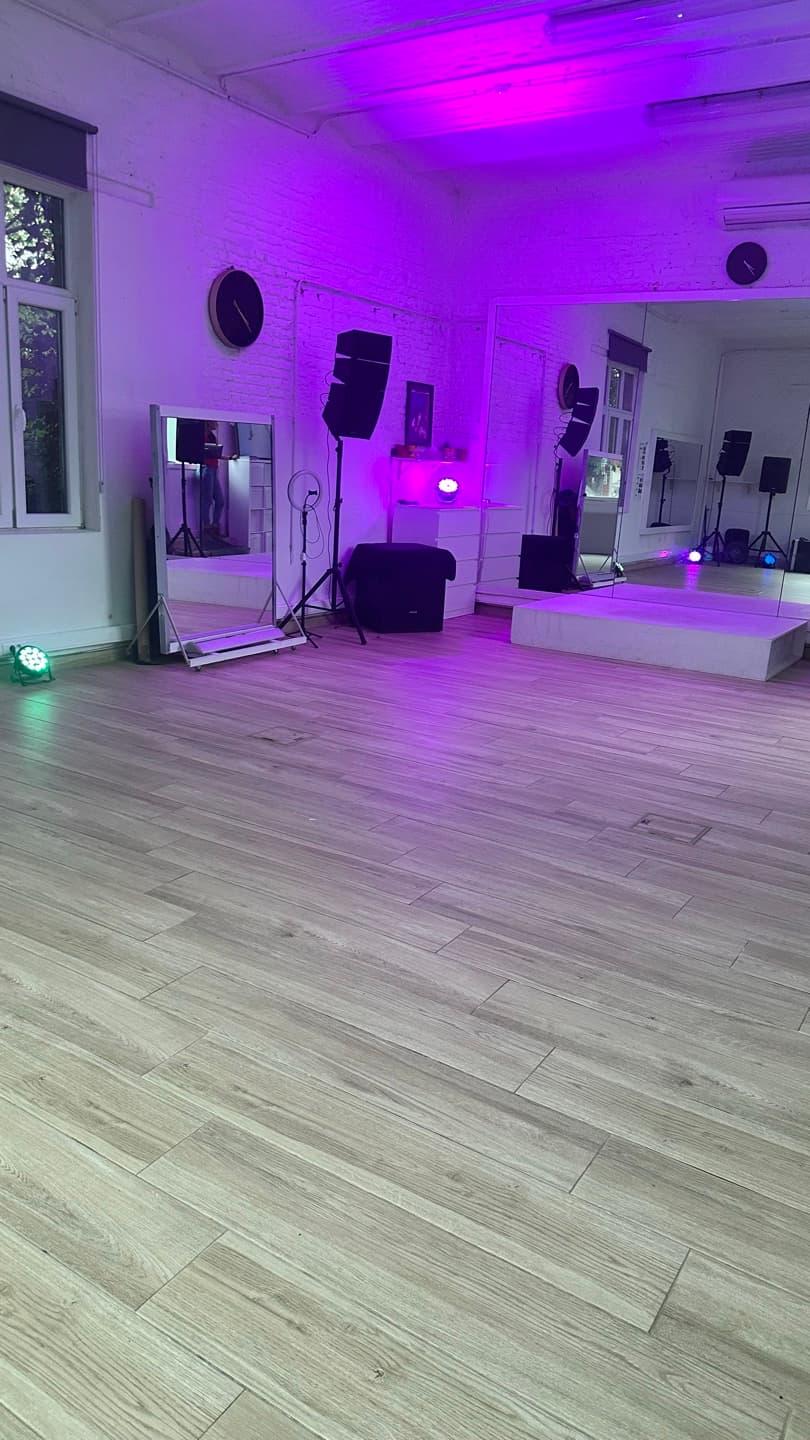 Le studio O'Dance sous un éclairage LED violet, grand mur de miroirs